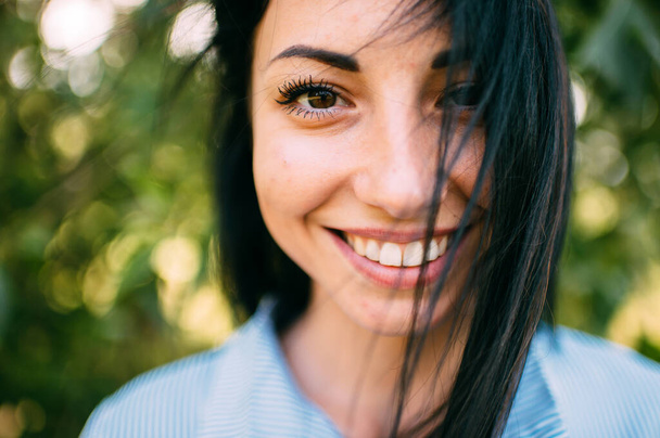Portrait of handsome young caucasian girl with big brown eyes, long dark hair and perfect smile on the green background - Φωτογραφία, εικόνα