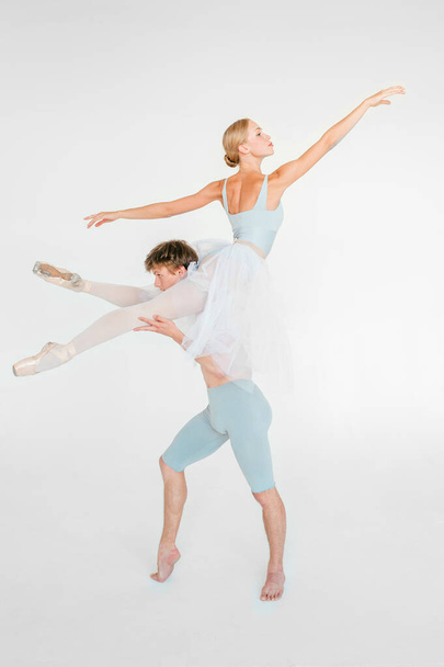 Young couple of modern ballet dancers posing over white studio background - Foto, immagini