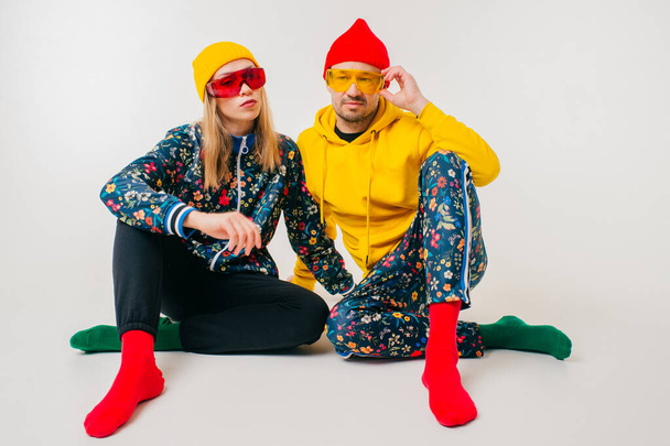 Stylish couple of man and woman in colorful clothes posing over white background - Zdjęcie, obraz