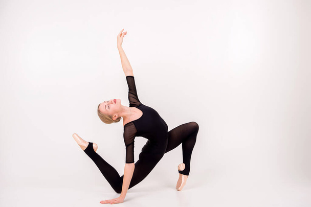Gymnastics female acrobat in the back bend pose, gymnastics girl strong flexible body over white background - Foto, Imagen