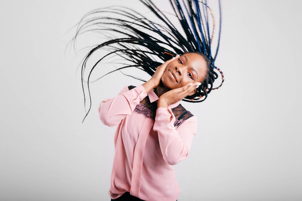 Happy cheerful african american girl shaking her head with dreadlocks on white background. - Foto, imagen