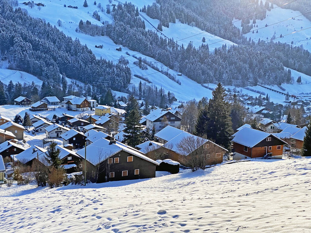 Idyllinen Sveitsin Alppien vuoristo mökit ja perinteinen Sveitsin maaseudun arkkitehtuuri pukeutunut talvivaatteita ja raikas lumipeite Obertoggenburgin alueella, Unterwasser - Canton of St. Gallen, Sveitsi (Schweiz) - Valokuva, kuva