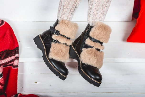 Nők fekete bőr csizma télre. Meleg cipő szőrme béléssel. A közelgő tél koncepciója, cipőt árulni nőknek. - Fotó, kép