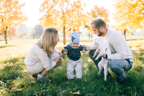 Happy family outdoor activity. Young  parents playing with their child in autumn park. - Fotó, kép