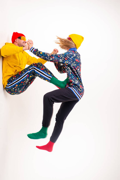 Stylish couple of man and woman in colorful clothes posing  over white background - Foto, immagini