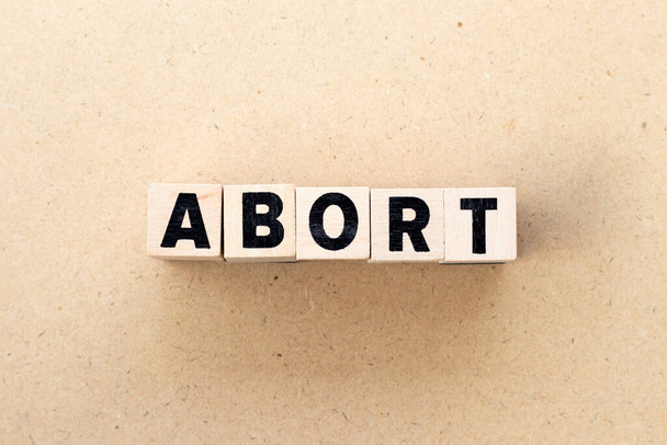 Letter block in word abort on wood background - Foto, Imagen