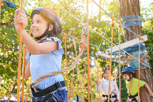 Little girl climbing in adventure park - Fotó, kép