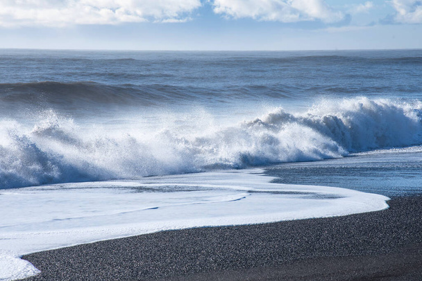 Beautiful winter view of picturesque Atlantic Ocean in Iceland. A waves of the Atlantic Ocean hit the coast of Iceland. The coast of Atlantic Ocean in winter. - Фото, изображение