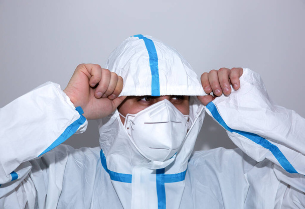 Lääkäri yllään lääketieteellinen suojapuku, suojalasit, naamio, ja käsineet. Suojelijoita virusepidemian avulla. Coronavirus (COVID-19). Terveydenhuollon käsite. - Valokuva, kuva