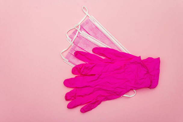 Fashion masks and glamour gloves isolated on pink background. Medical products for personal hygiene and the prevention of viral diseases. Coronavirus, COVID-19 pandemic, 2019-nCoV worldwide concept - Zdjęcie, obraz