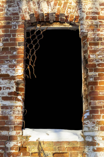 mur de briques avec ouverture de fenêtre sculptée, fond noir - Photo, image