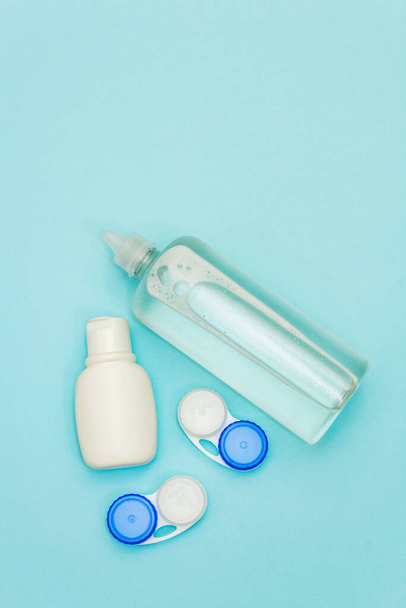 Reiseset für Kontaktlinsen. Desinfektionsmittel, Lösung, Behälter. hellblauer Hintergrund - Foto, Bild