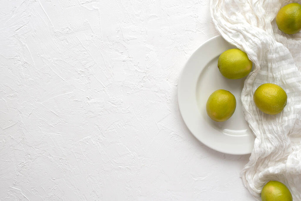 Lime on a plate on a white background, top view. Copy space. - Фото, зображення