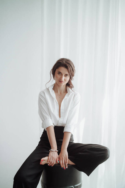 young beautiful woman in white shirt posing in studio - Foto, Imagen