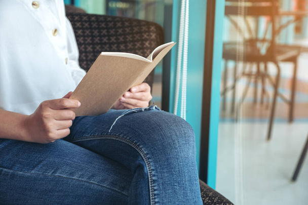 Imagen de cerca de una mujer sosteniendo y leyendo un libro  - Foto, imagen