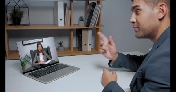 Zakenman in gesprek met collega tijdens skype conferentie op laptop  - Video