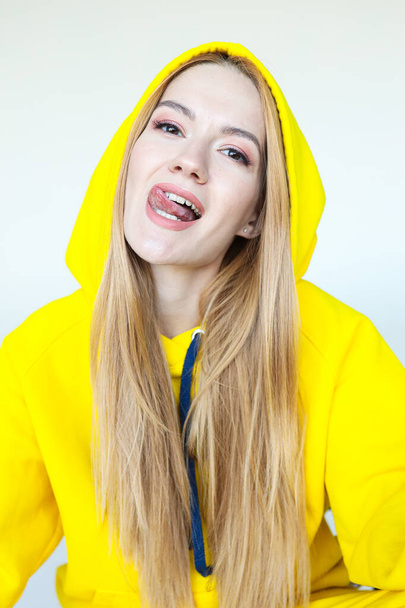 A young woman poses in a bright yellow tracksuit - Foto, Imagem