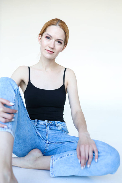 Portrait of a young woman in jeans and a black t-shirt - Foto, Imagen