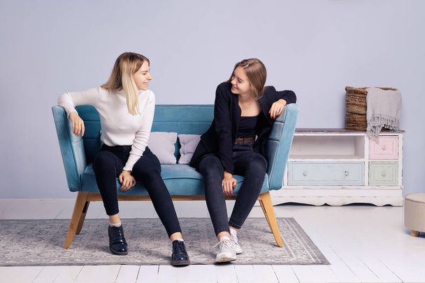 Two girls talking together on the couch. Friendship and teenager relations. - Fotoğraf, Görsel