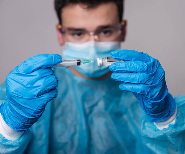 Doctor's hands inserting the syringe into the Covid-19 vaccine vial - 写真・画像