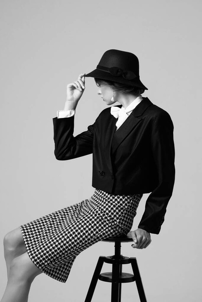 High fashion portrait of elegant woman in retro look. Black and white image, hat, jacket, skirt - Fotó, kép