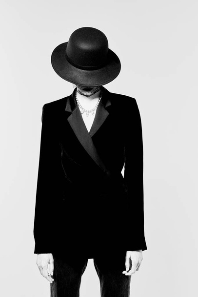 High fashion portrait of elegant woman in retro look. Black and white image, black hat, jacket, necklace - Φωτογραφία, εικόνα