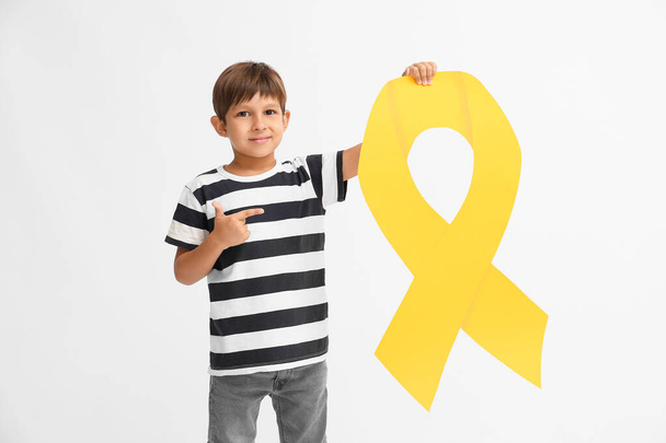 Mały chłopiec ze złotą wstążką na jasnym tle. Koncepcja świadomości na temat nowotworów u dzieci - Zdjęcie, obraz