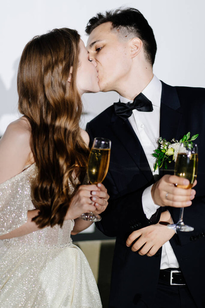 newlyweds with champagne in hands listen to toasts, congratulations and kiss - Фото, изображение