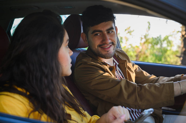 A shallow focus of a young happy Hispanic couple sitting in a car - Fotoğraf, Görsel