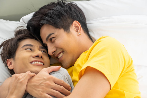 Asian gay homosexual couple hug and embracing on the bed.  Gender equality and right concept, playful and romantic moment. - Photo, Image