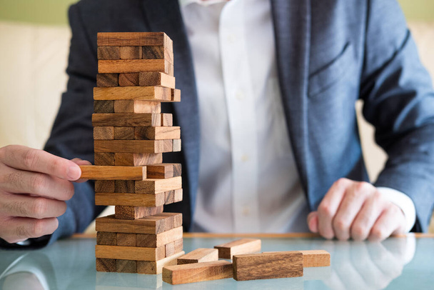 Selective focus at wood brick. Business people dress in formal suit taking risk and make decision to play the game. Insurance or financial risk management concept. - 写真・画像