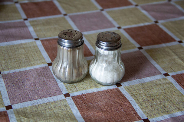 Перець шейкер і солоний шейкер на столі
 - Фото, зображення