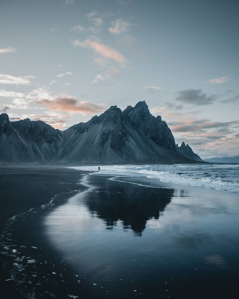 Een prachtig uitzicht op rotsachtige bergen reflecterend in een meer in IJsland - Foto, afbeelding