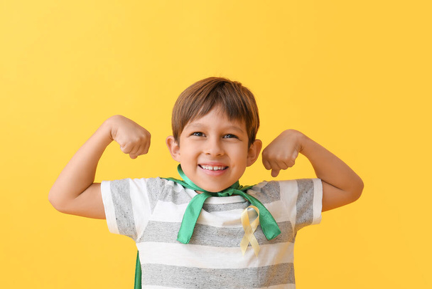 Pieni poika kultainen nauha yllään supersankari puku väri tausta. Lapsuuden syöpätietoisuuden käsite - Valokuva, kuva