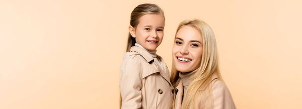 cheerful blonde mother and daughter isolated on beige, banner - Valokuva, kuva