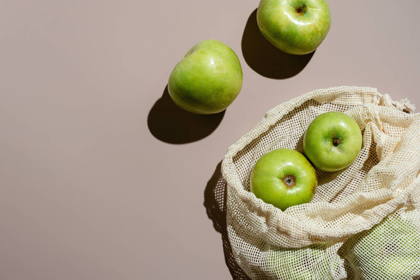 Flatlay of green organic apples in cotton zero waste mesh bag with copyspace, - Photo, image