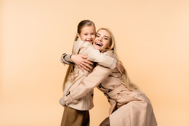 heureux enfant embrassant étonné blonde mère isolé sur beige - Photo, image