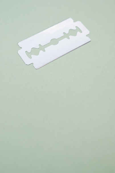 A vertical shot of blade isolated on light green background - Foto, Imagem