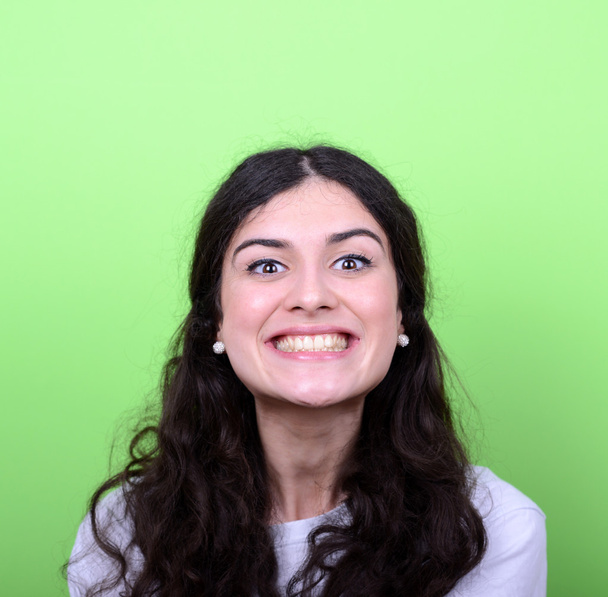 Portrait of beautiful young woman smiling against green backgrou - Zdjęcie, obraz