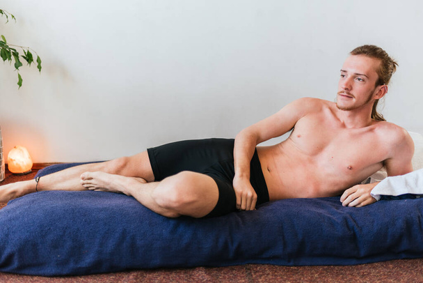 Stock photo of shirtless man lying in the floor and relaxing. - Foto, Imagen