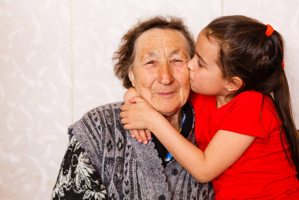 radosna młoda dziewczyna opiekuje się starszą kobietą w domu - Zdjęcie, obraz