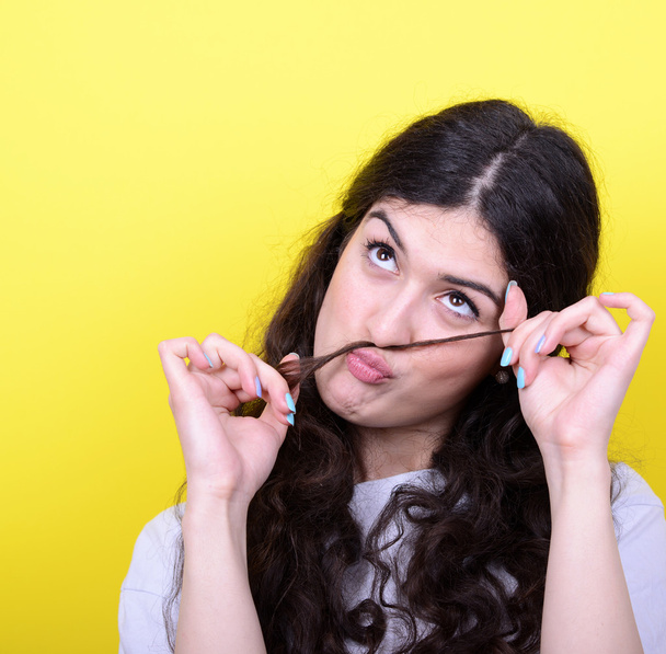 Porträt eines lustigen Mädchens mit Schnurrbart vor gelbem Hintergrund - Foto, Bild