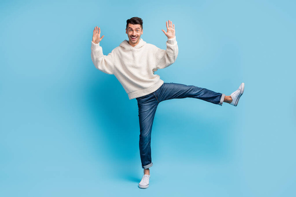 Photo portrait full body view of man standing on one leg spreading like star wearing woolen hoodie isolated on pastel blue colored background - Valokuva, kuva