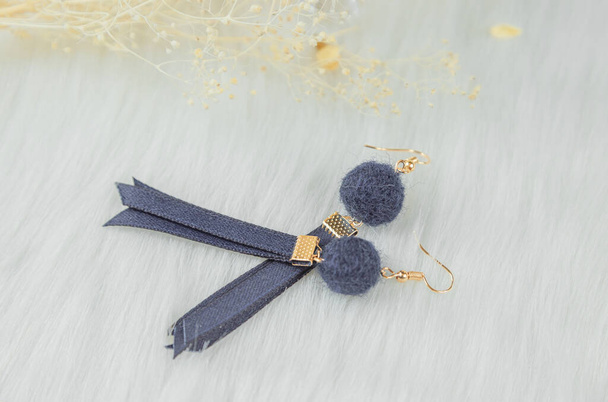 Blue handmade earrings. Matched with the dry yellow bouquet. Put it on the white woolen blanket. It looks very stylish and elegant. - Photo, Image