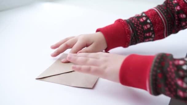kids hands drawing heart on craft envelope with red paper heart. valentine day - Footage, Video
