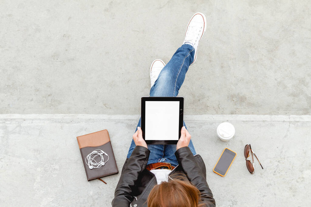 Chica sentada con una tableta en las manos. Vista superior. Concepto de operación remota. Estudiantes de educación en línea. Compras online - Foto, imagen