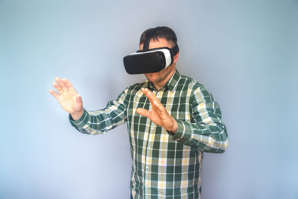 Młody człowiek używający okularów VR - Młody hipster noszący zestaw słuchawkowy VR - Modny facet noszący google VR. Zabawa, technologia, styl życia i koncepcja przyszłości - ciepły filtr. Skup się na okularach. Mody facet w VR słuchawki.  - Zdjęcie, obraz