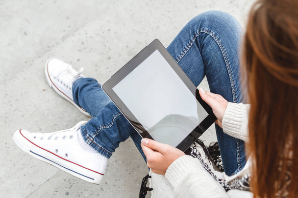 Girl sitting with a tablet in hands. Top view. Remote operation concept. Online education students. Online shopping - Foto, Imagen
