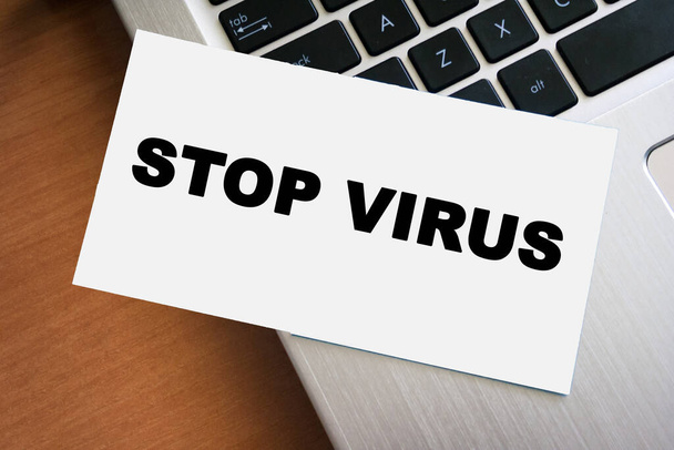 STOP VIRUS inscription on white paper note on laptop keyboard. Goodbye coronavirus. Closeup message. - Fotó, kép