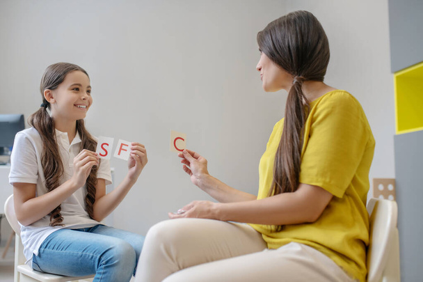 Girl and woman holding cards with letters - Foto, imagen